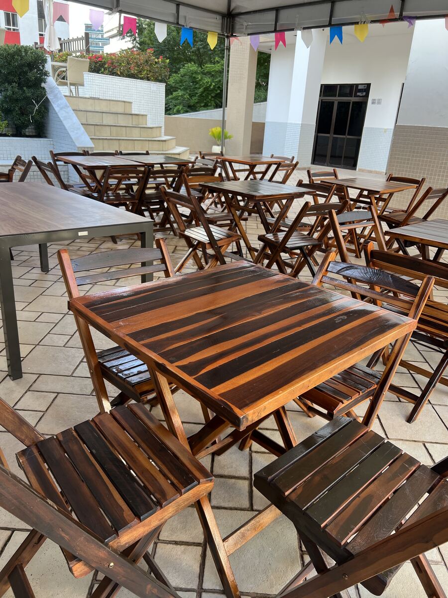 Mesas e cadeiras montadas sob tenda